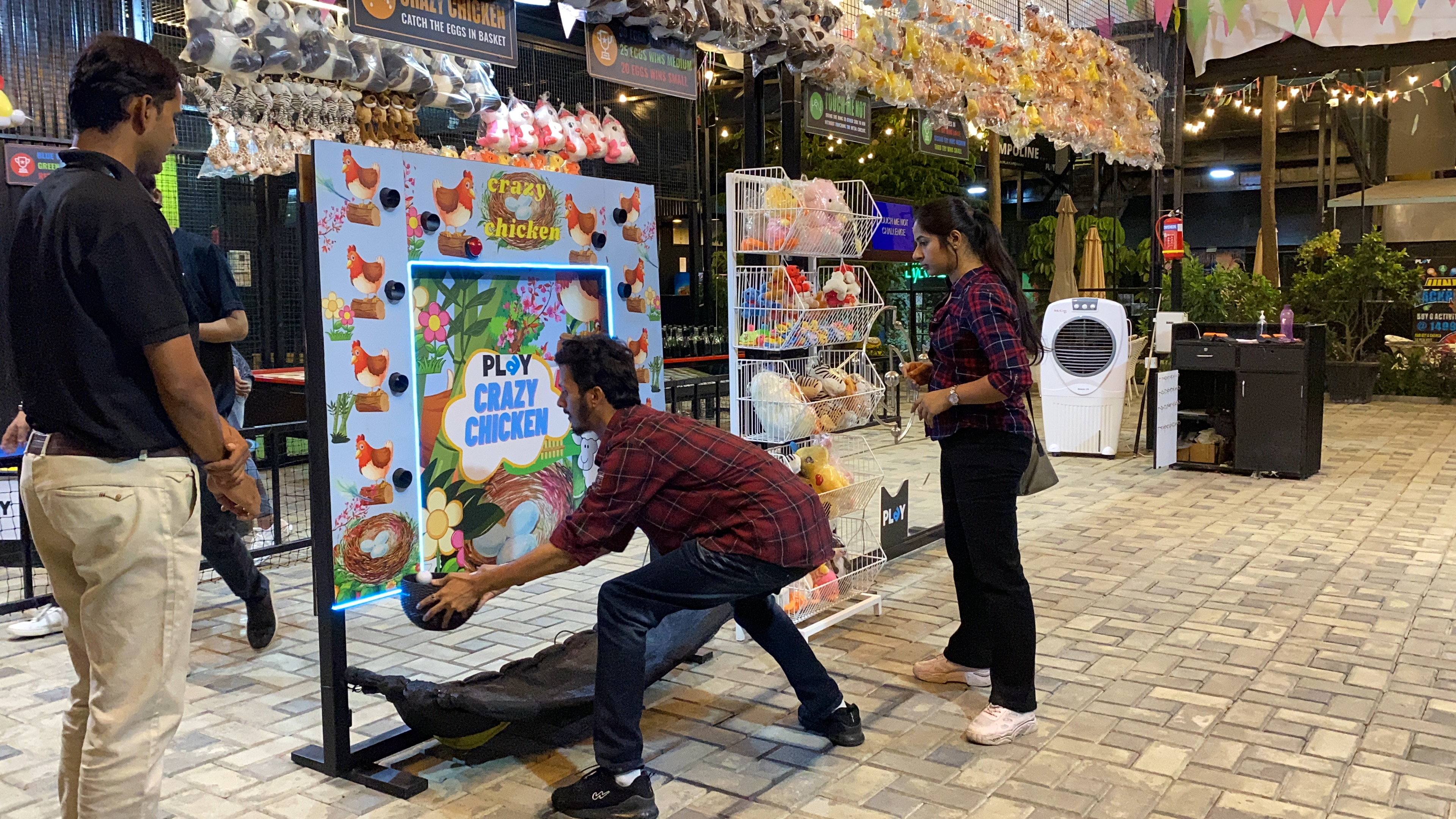 crazy chicken egg drop game in action, kids catching falling eggs, colorful LED lights, bright arcade interior, dynamic family fun, professional photography