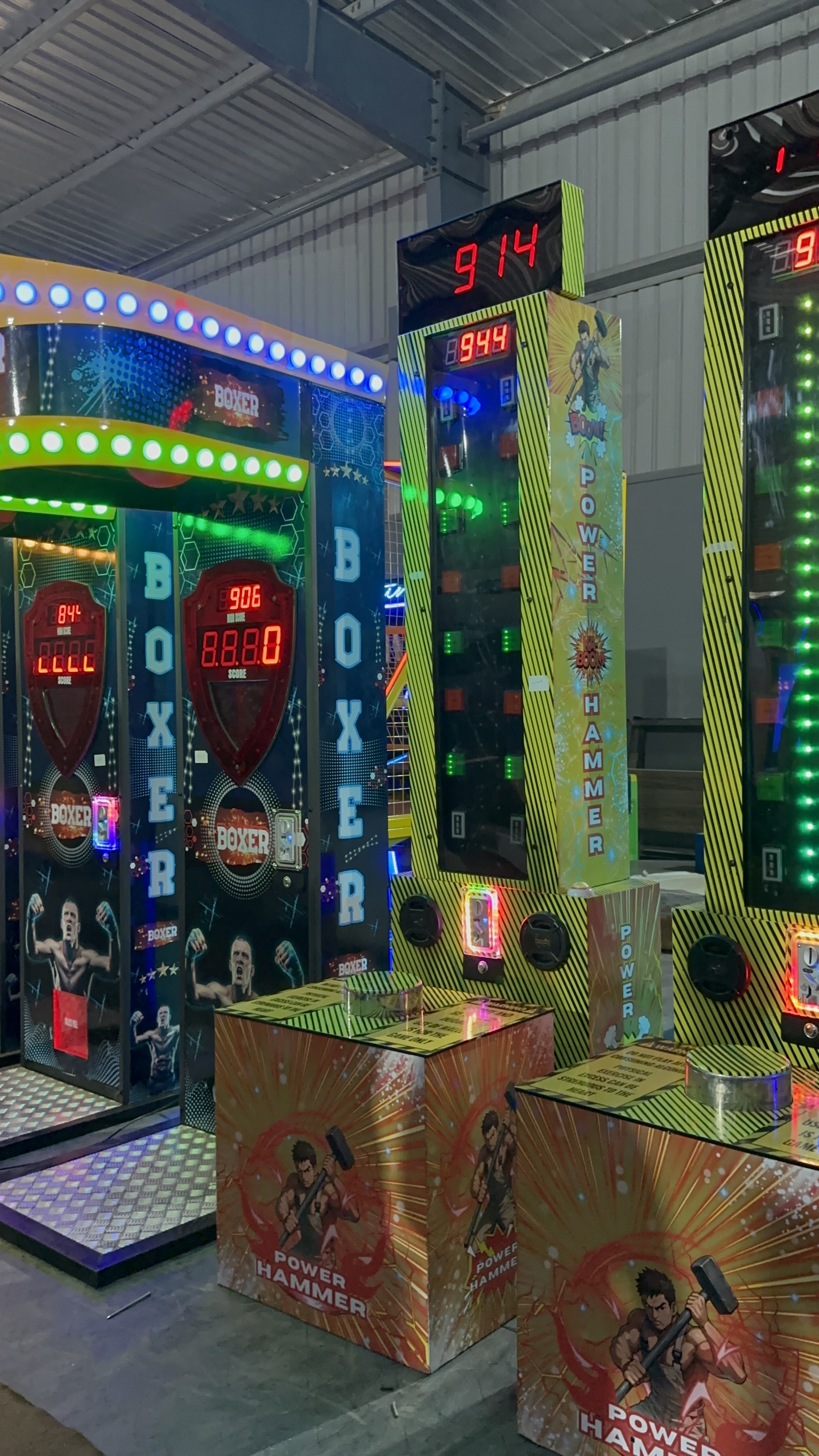 digital hammer strength tester in action, person striking pad with mallet, vertical LED score tower glowing, arcade environment, dramatic lighting, professional photo