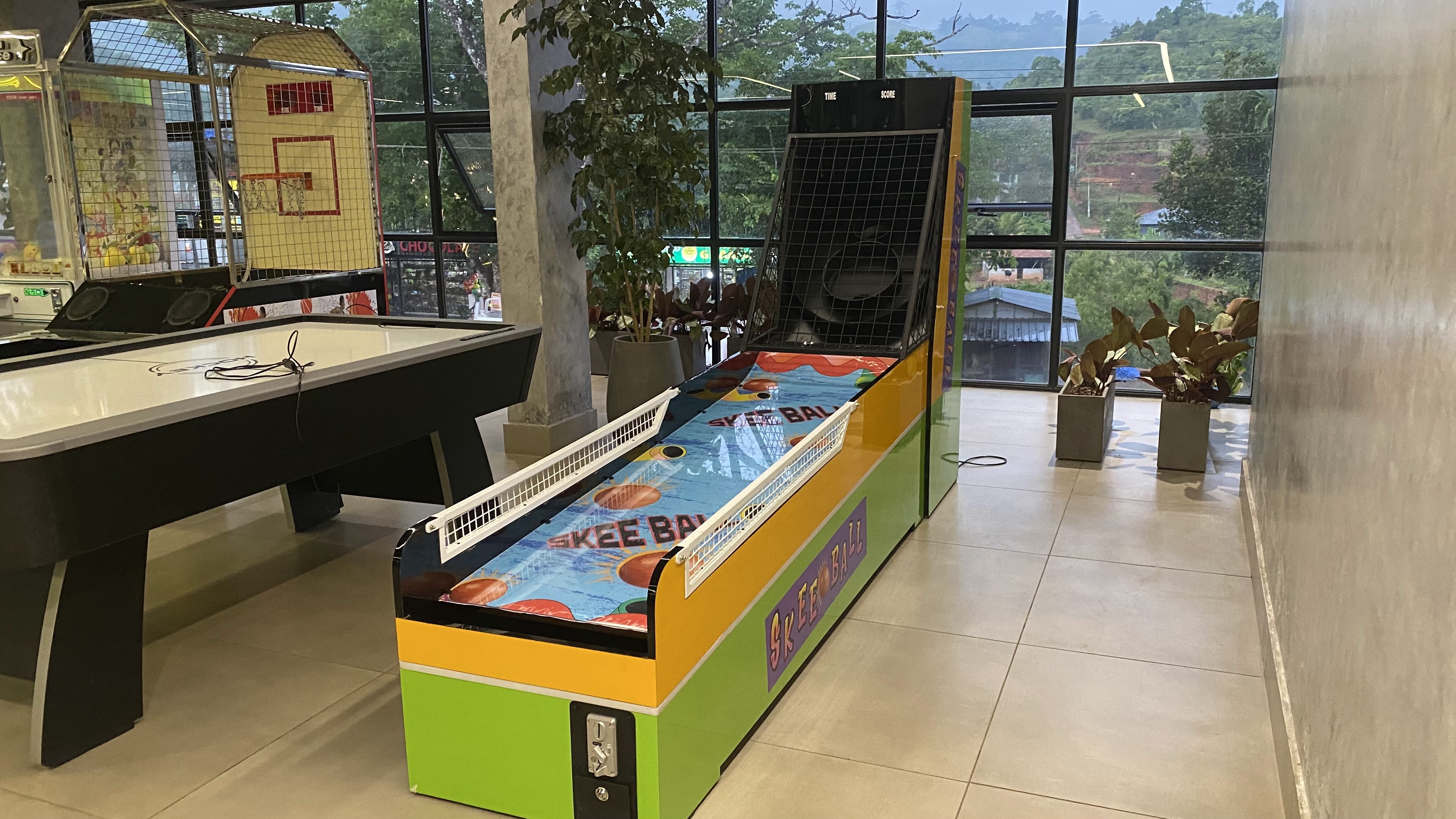 skee ball arcade machine in action, player rolling ball up ramp, LED scoreboard glowing, family entertainment center, vibrant lighting, professional photography